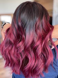 the back of a woman's hair with a pink ombre