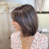 a woman in a floral top with a bob haircut