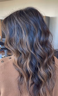 the back of a woman's hair with dark brown and wavy wavy hair