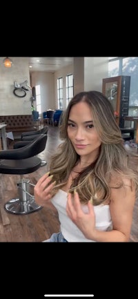 a woman is sitting in a chair in a salon