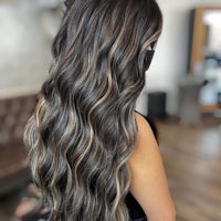 a woman with long wavy hair in a salon
