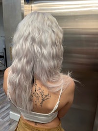 the back of a woman with white wavy hair