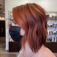 a woman wearing a face mask in a hair salon