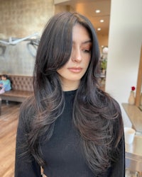 a woman with long black hair in a salon