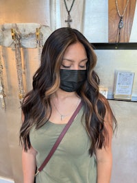 a woman wearing a black mask in front of a jewelry store