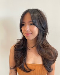 a young woman with long hair posing for a photo