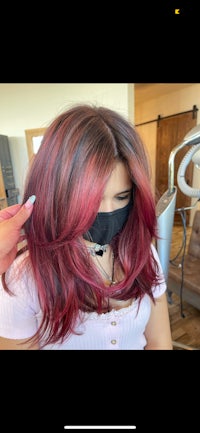 a woman with red hair is getting her hair dyed