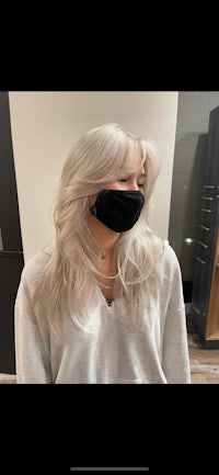 a woman wearing a face mask in front of a mirror