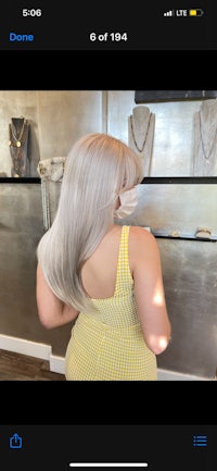 a woman in a yellow dress is standing in front of a mirror