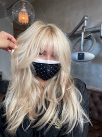 a woman wearing a face mask in a salon